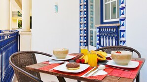 Una mesa dispuesta con cosas para el desayuno, incluyendo un cuenco, un plato con un pastel y un vaso de jugo de naranja.