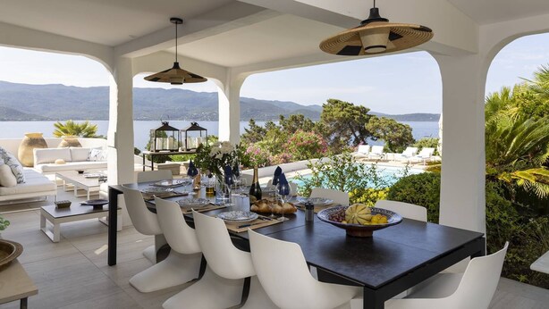 A dining area with a table set for four, overlooking a pool and mountains. - VILLA IRIS-Feet in the water, Isolella peninsula, 5 bedrooms, swimming pool, sea view (PIETROSELLA)