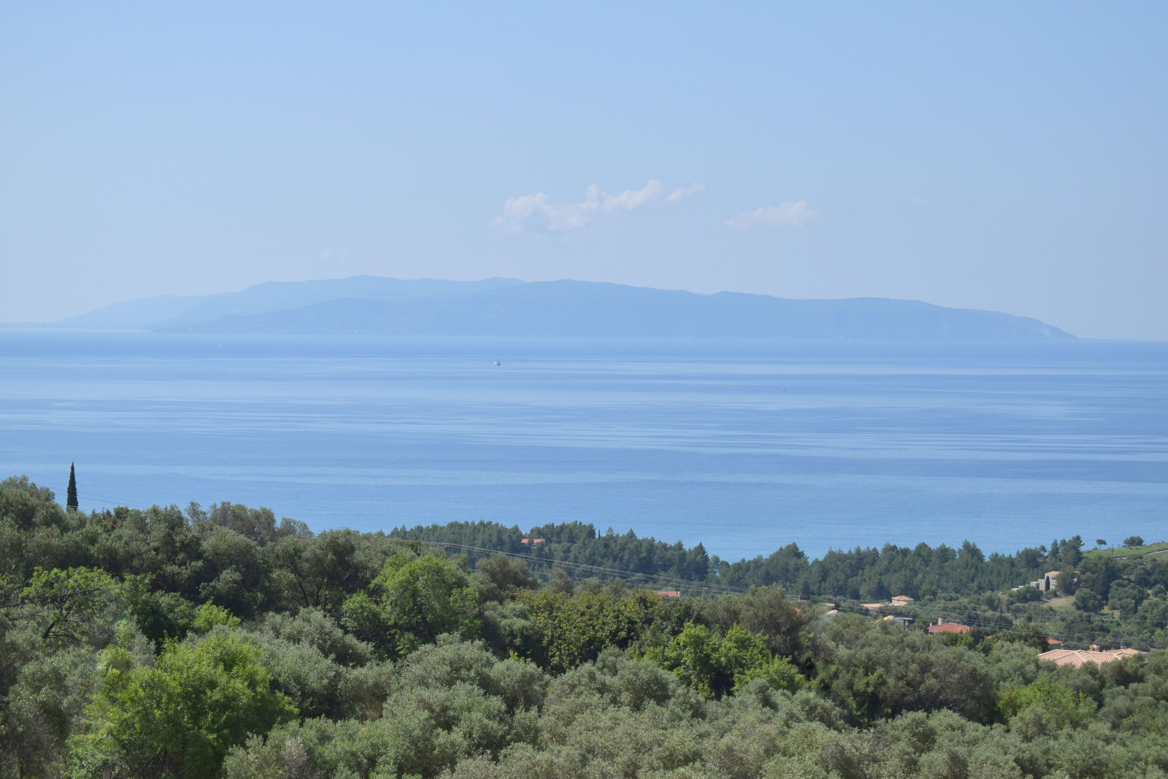 Eine Küstenlandschaft mit Blick auf das Meer und ferne Berge.