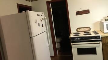 A kitchen with a white refrigerator, a stove, and a microwave.