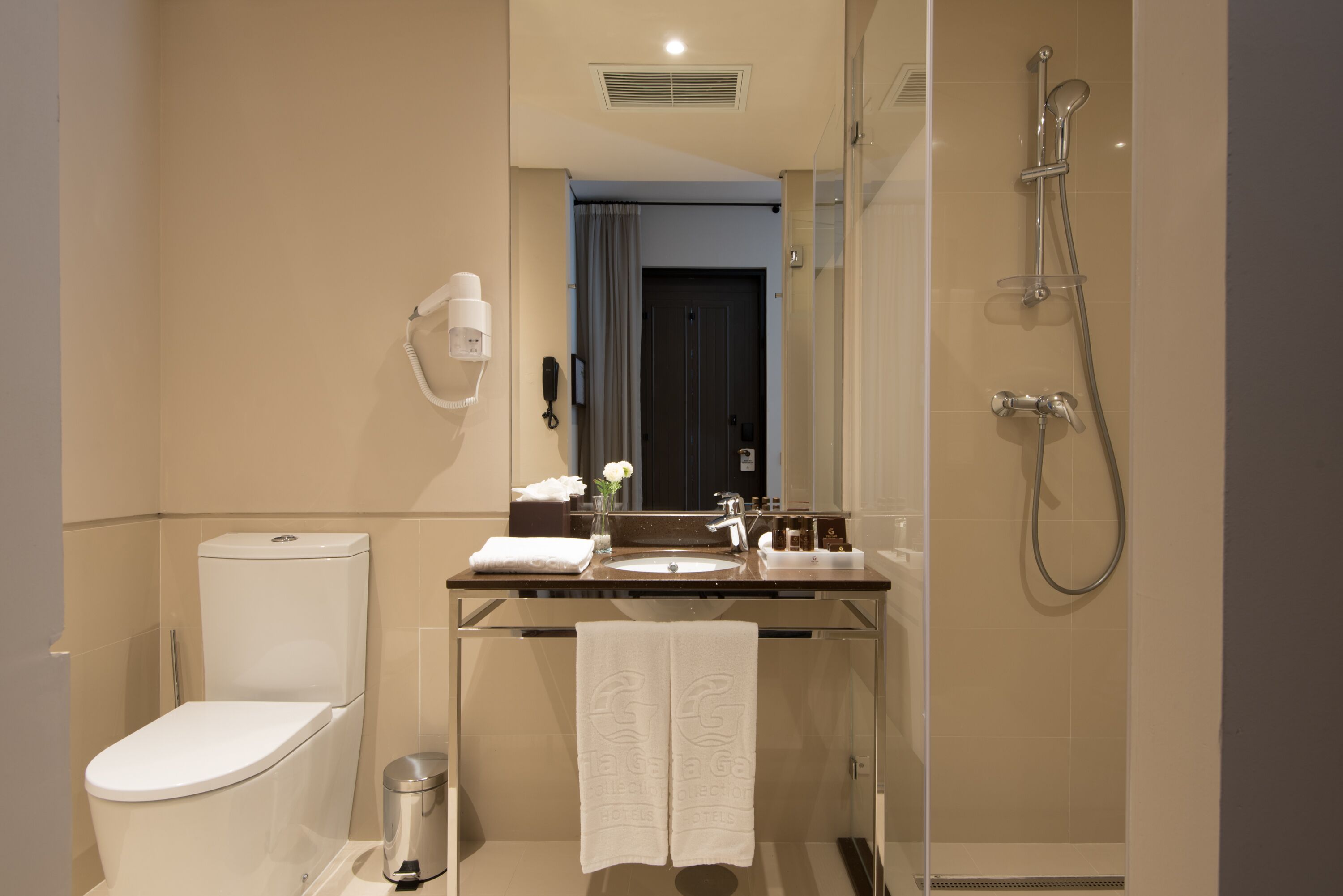 A modern bathroom with a toilet, sink, and shower.