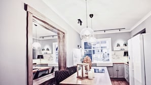 A modern kitchen with a large mirror, pendant lights, and a wooden island. - Heart of Reykjavik (Reykjavik)