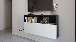 Un soggiorno moderno con una televisione a schermo piatto montata su un mobile bianco.