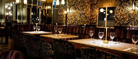 Un restaurante con cabinas y mesas, cada una con una copa de vino.