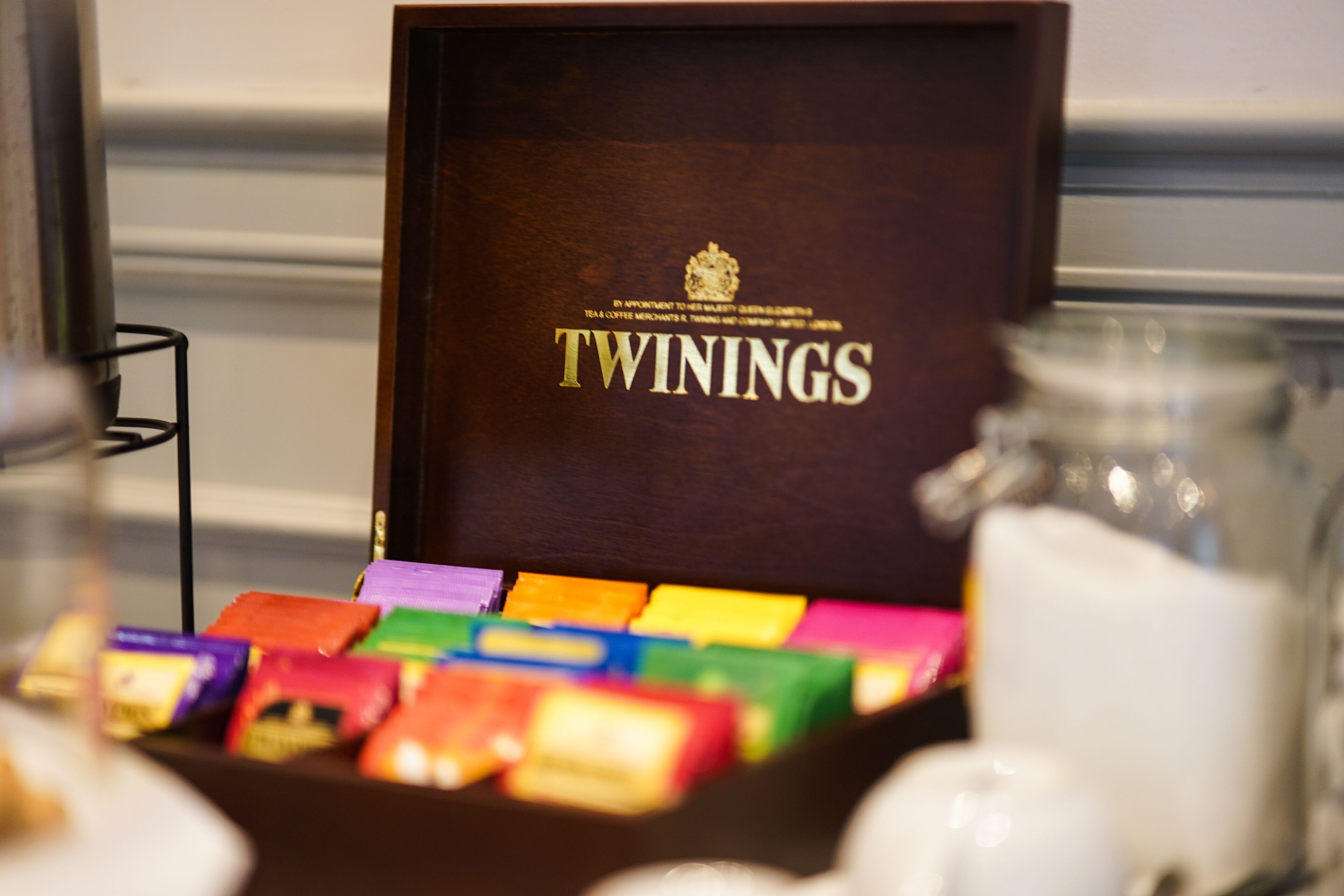 Una caja de té Twinings con una variedad de bolsitas de té de distintos colores.