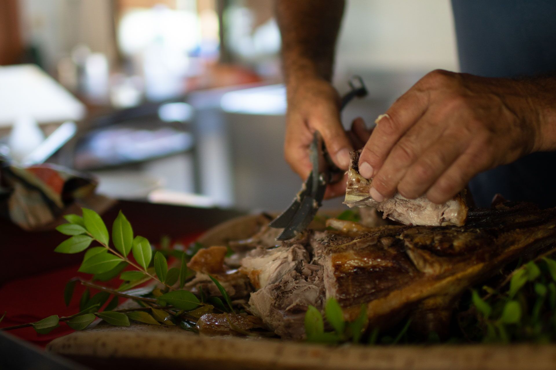 A person carving meat on a cutting board with a knife.