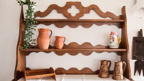 Una estantería de madera con macetas de terracota y un adorno.