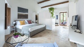 A bedroom with a bed, bedside table, and a hanging plant. - Margana Palace by ROMAC (Rome)