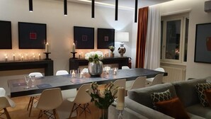 Un comedor moderno con una larga mesa, velas y un florero con flores.