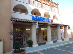 A building with the sign "MARCHEU" indicating a restaurant or cafe. - Cap Estérel Apt 4 pers air conditioned with WIFI- Bat C9 shopping street and quiet  (agay)
