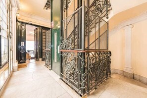 A corridor with ornate metal railings and a staircase.