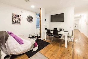 A compact living space with a bed, a desk, and a TV. - TET (Madrid)