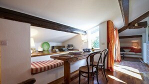 A cozy dining area with a wooden table, chairs, and a bench. - A Romantic Retreat in Florence.  (Firenze)