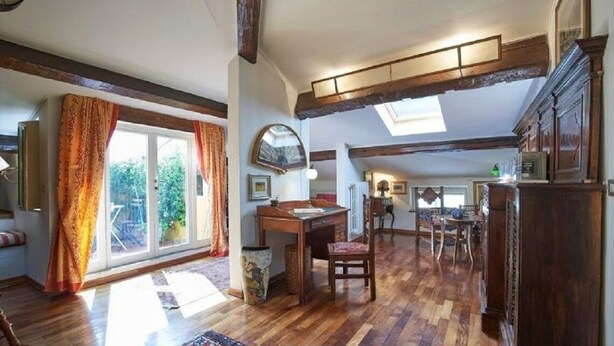 A spacious room with a wooden floor, a desk, a chair, and a window with curtains. - A Romantic Retreat in Florence.  (Firenze)