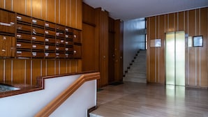 Ein hölzerner Empfangstresen mit einer Treppe, die zu einem Aufzug führt.