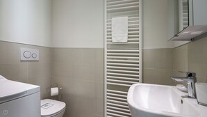 A modern bathroom with a toilet, sink, and towel rack. - Italianway - Giuseppe Pastine 17/D (Santa Margherita Ligure)
