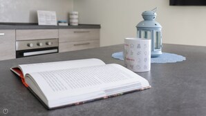 A kitchen counter with a book, a mug, and a blue lantern. - Italianway - Giuseppe Pastine 17/D (Santa Margherita Ligure)