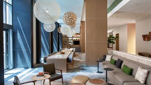 A modern hotel lobby with a long reception desk, seating area, and large windows allowing natural light. - Element by Marriott Philadelphia Downtown (Philadelphia)