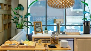 A café with a wooden counter, a chalkboard menu, and a variety of food items. - Element by Marriott Philadelphia Downtown (Philadelphia)