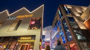 Ein modernes Gebäude mit einem gut sichtbaren 'intu Watford'-Schild, einem 'FRIDAYS'-Schild und einer Glasfassade.