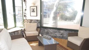 Habitación con muebles de mimbre, una mesita de centro y vistas al exterior.