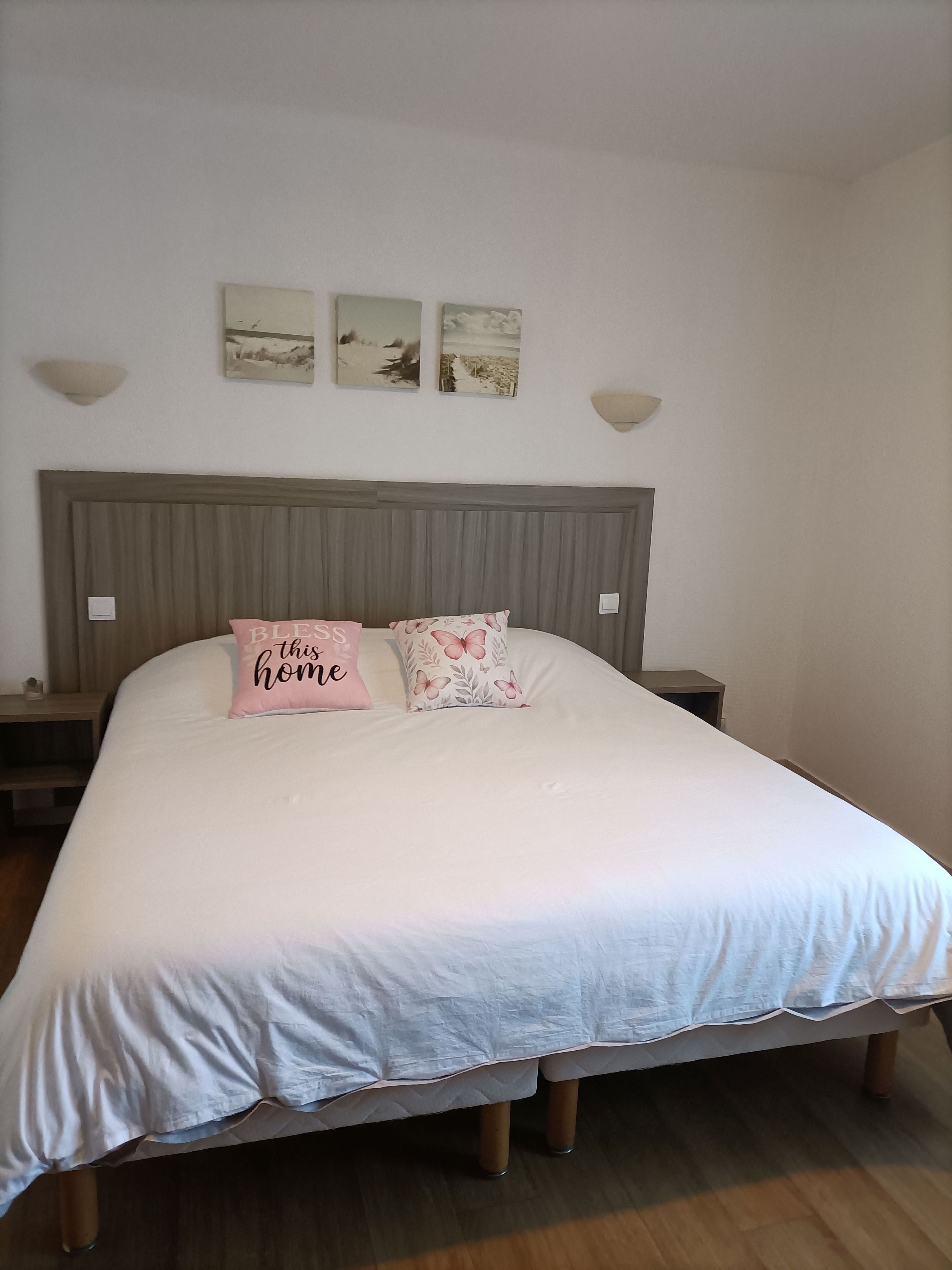 A bedroom with a large bed, two bedside tables, and a headboard.