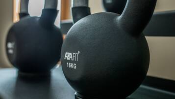 Pesas rusas con la etiqueta "AZAFIT 16KG" en equipo de gimnasio.