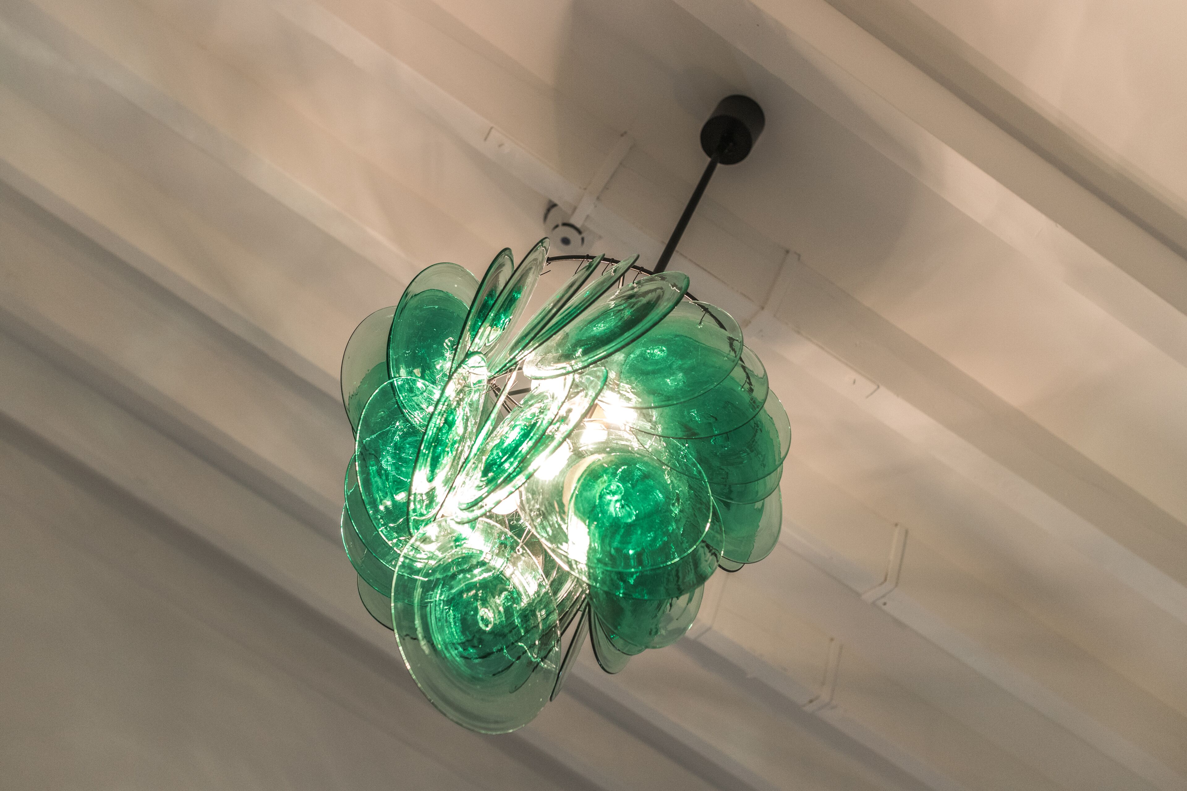 A ceiling with a green glass chandelier.