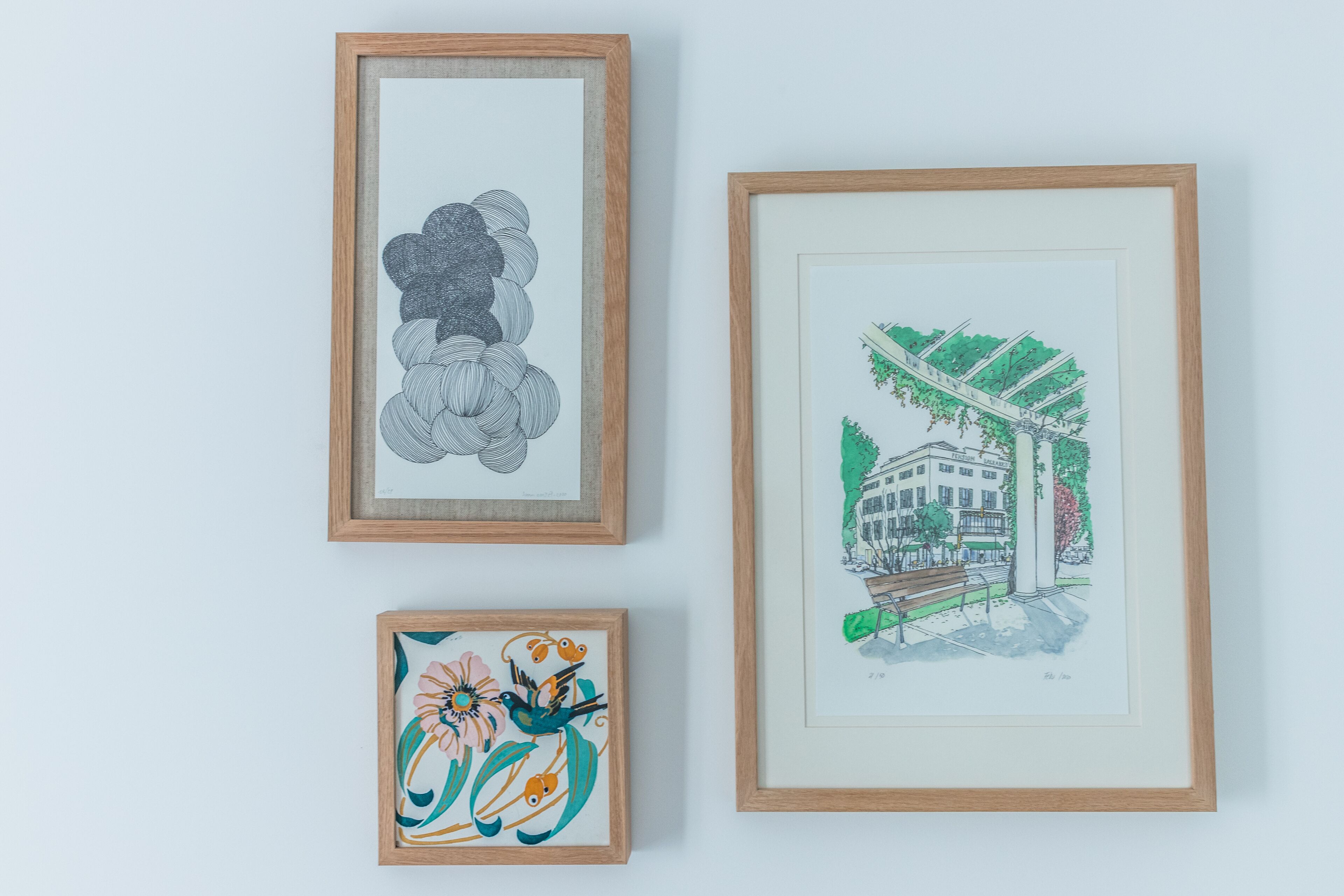 Three framed artworks on a wall.