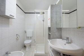 A modern bathroom with a toilet, bidet, shower, and sink. - Lovely Flat with swimming pool near beach (Vinkuran)