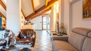A spacious living area with a high ceiling, a fireplace, and a dining area in the background. - Casa Erica (Bologna)