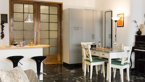 A compact living space with a dining area, a piano, and a large mirror. - Bologna Centrale Flat (Bologna)