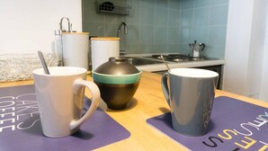 A kitchen with a stove, sink, and a coffee maker. There are three mugs on the counter. - Bologna Centrale Flat (Bologna)