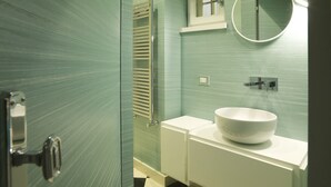 Ein Badezimmer mit einem weißen Waschbecken, einem Spiegel und einem Handtuchhalter.