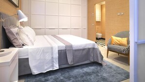 Ein Schlafzimmer mit Bett, Nachttisch, Lampe und Stuhl.