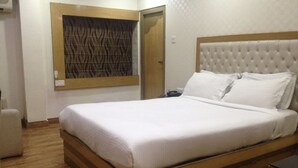 A neatly made bed with a tufted headboard in a hotel room. - Ashreen Guest House (Kolkata)