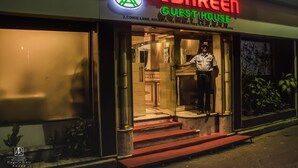 A guesthouse named Ashreen with a signboard, a mannequin dressed in uniform, and steps leading to the entrance. - Ashreen Guest House (Kolkata)