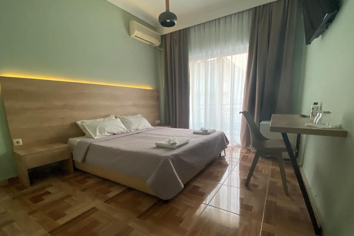 Ein Hotelzimmer mit Bett, Nachttisch und Schreibtisch mit Stuhl.