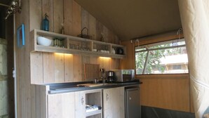 Une cuisine en bois avec des étagères intégrées, un évier et un four à micro-ondes.