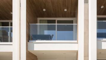 A modern two-story building with a balcony on the upper floor, large windows, and a flat roof.