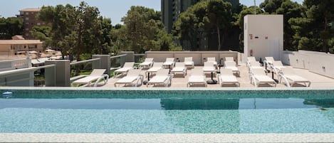 Piscine extérieure, parasols de plage, chaises longues