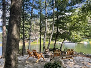 A lakeside patio with Adirondack chairs and a fire pit. - Private Hot Tub & Panoramic Lake views, Side x Side Trails, Pet Friendly! (Gaylord)