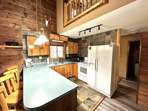 Enjoy cooking in this well-equipped kitchen with a central island, oven, and refrigerator.