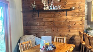 Una sala da pranzo in legno con un tavolo grande, sedie e un lampadario.