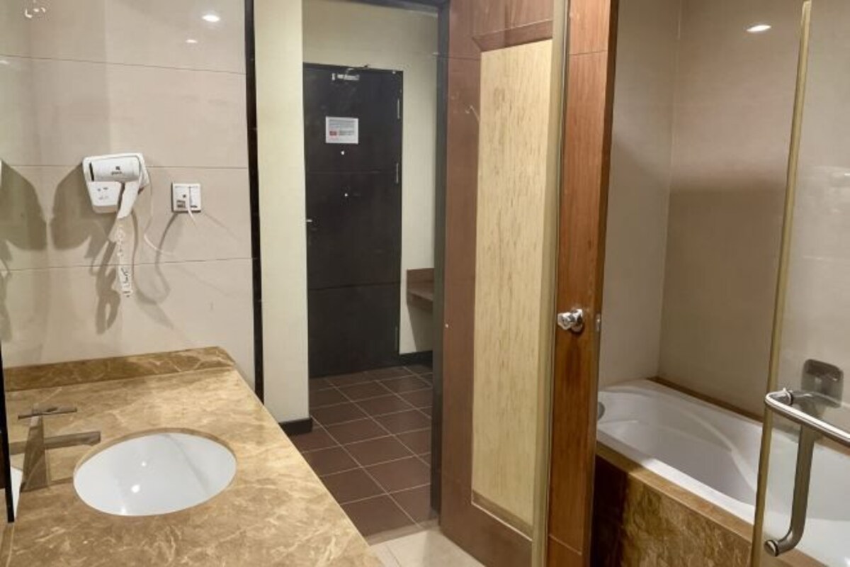 A bathroom with a marble sink, a shower with a glass door, and a toilet.