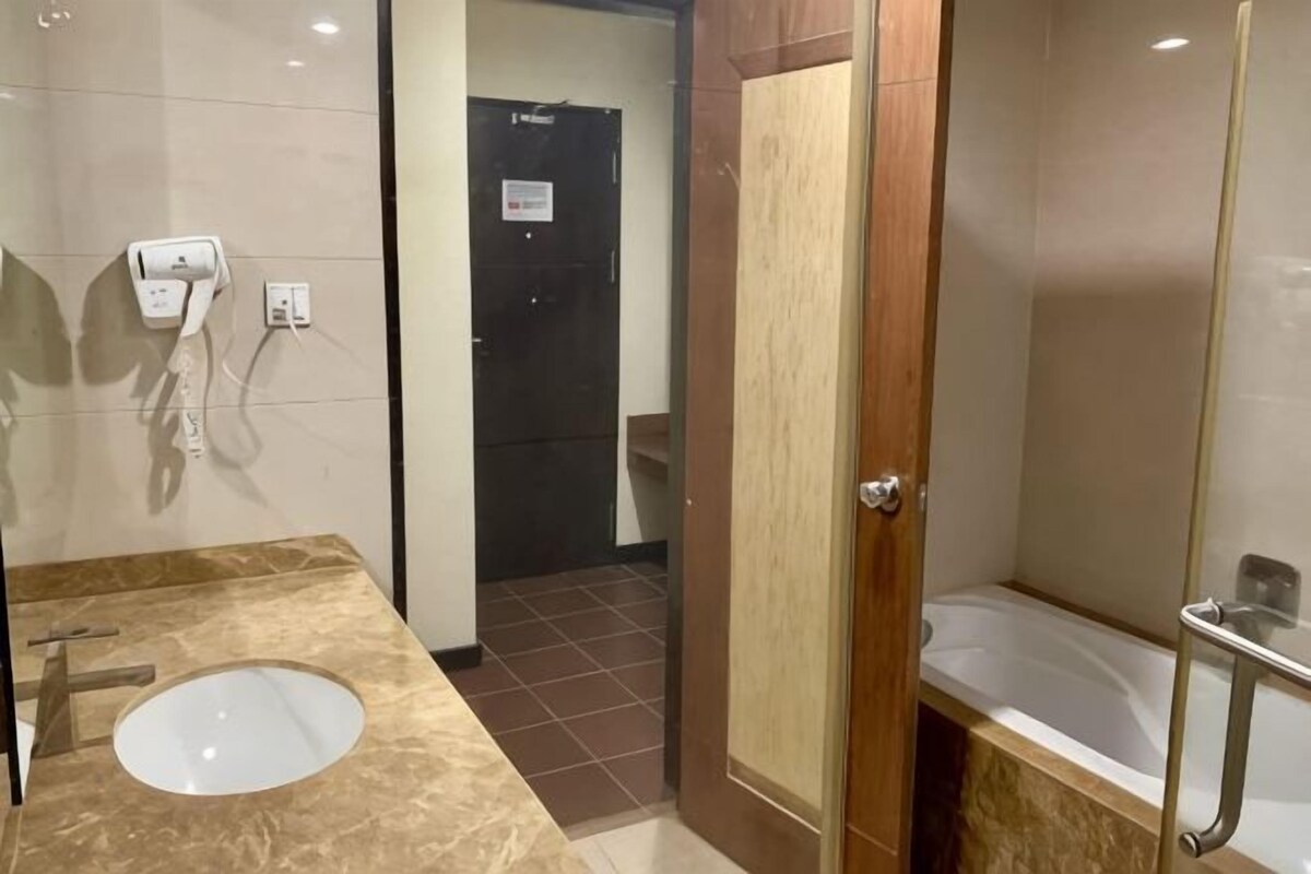 A bathroom with a marble sink, a shower with a glass door, and a toilet.