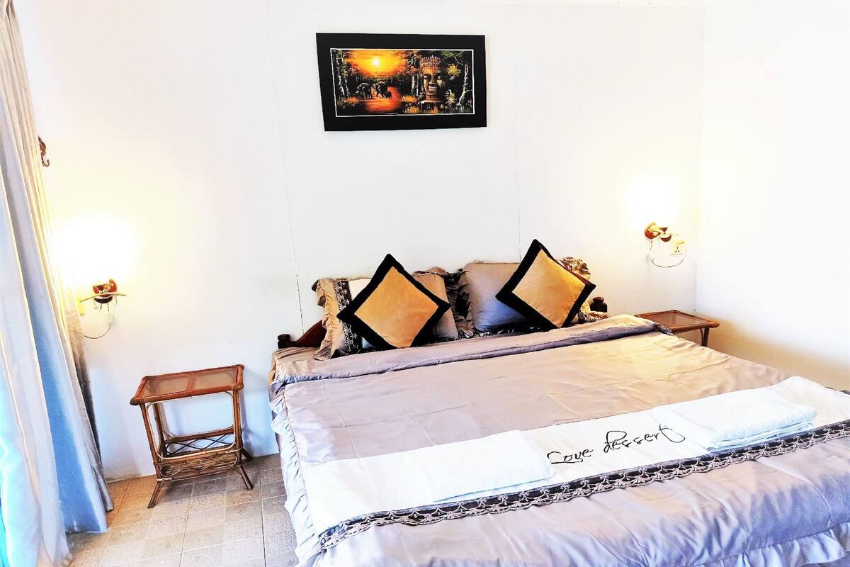 A neatly made bed with a decorative pillow and a sign that reads "Couple dessert."