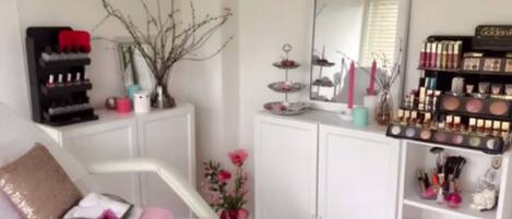 A well-organized vanity area with a mirror, makeup shelves, and a small plant.