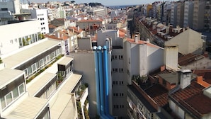 A high-rise building with a central blue water feature, surrounded by other buildings. - D&N Hospedagem - Hostel (Lisbon)