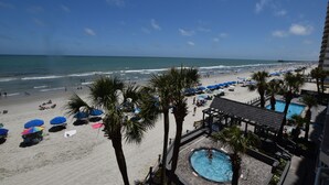 A beach resort with a pool, palm trees, and beach umbrellas. - 0303 Waters Edge Resort 1 Bedroom Condo by RedAwning (Murrells Inlet)